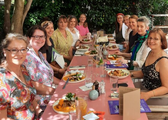 Frauen eines Business Netzwerkes bei einem Lunch in einem Gartenrestaurant.