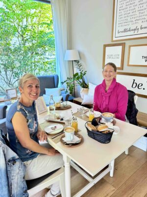 Zwei Frauen an einem gedeckten Frühstückstisch